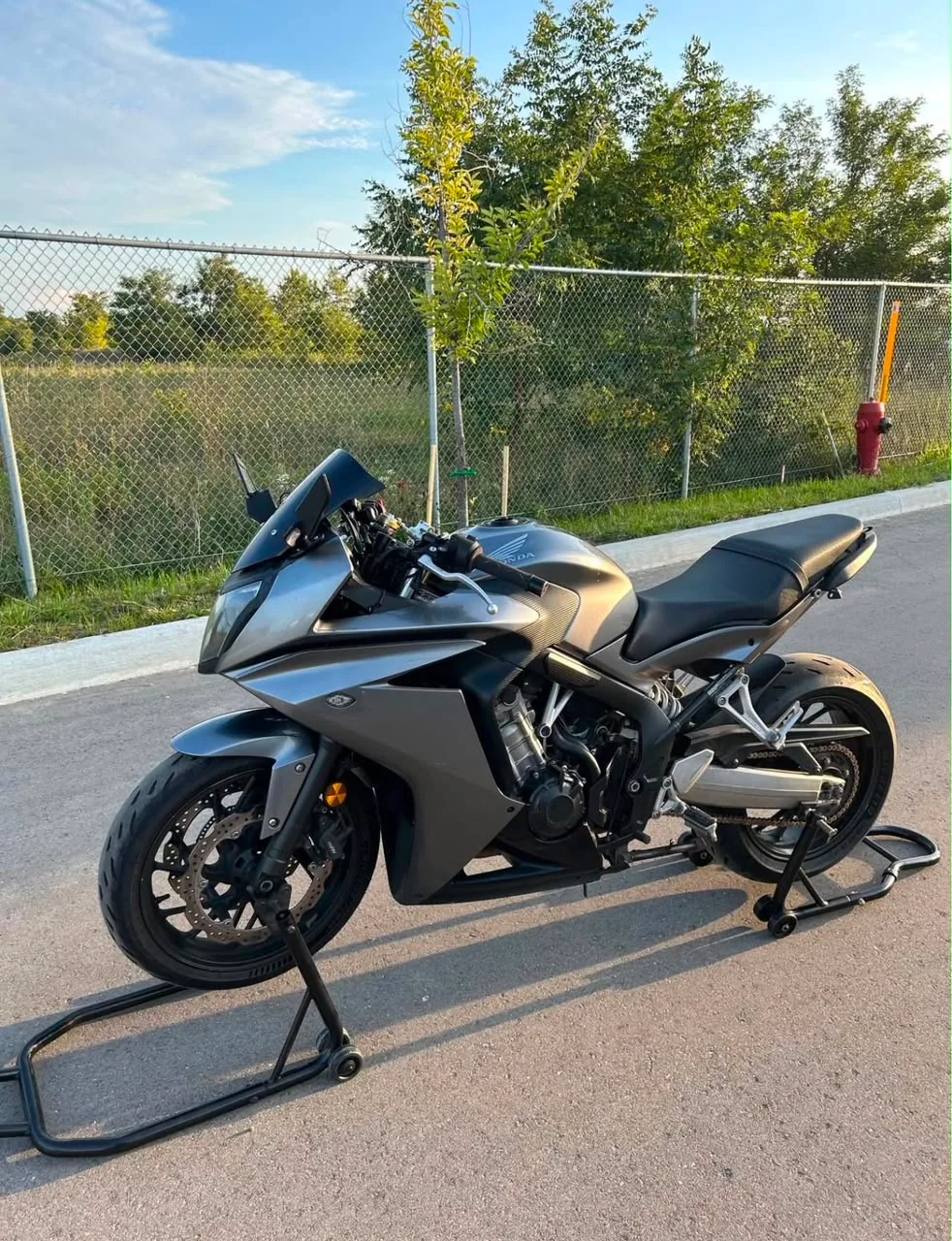2014 Honda CBR in gunmetal grey, left-hand side profile, on paddock stands